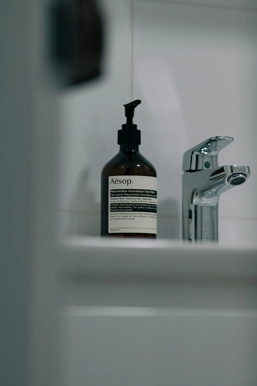 Anonymous person in yellow rubber gloves using simple sponge for cleaning mirror in bathroom
